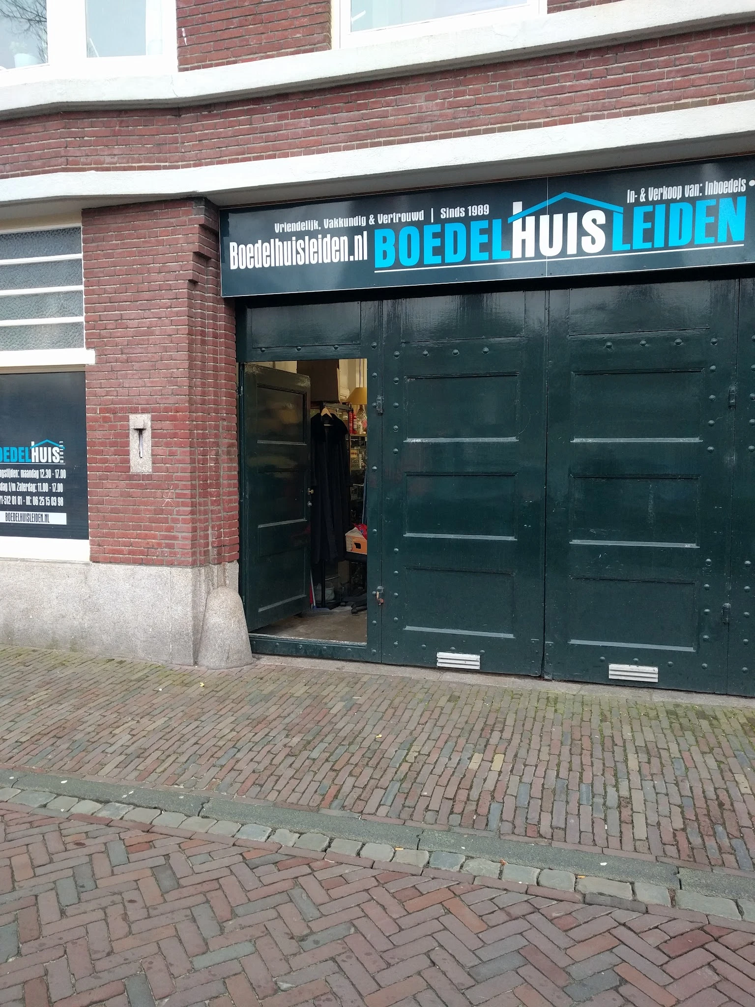 Donkergroene deuren en gevel van kringloopwinkel Boedelhuis aan de Oude Vest in Leiden