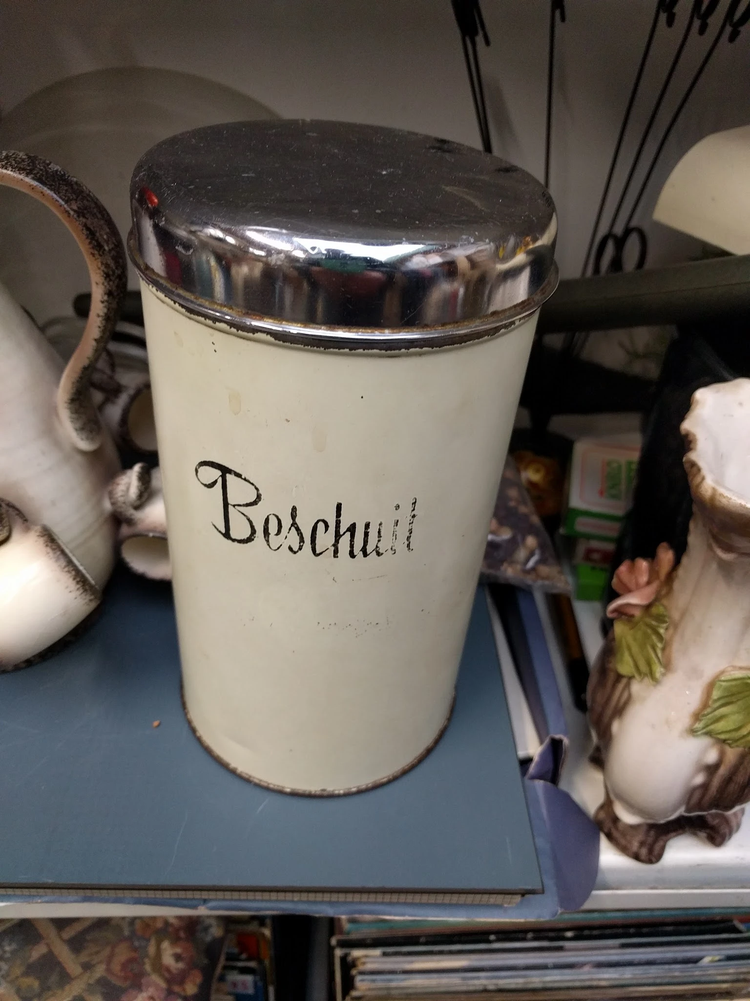 Witte porseleinen pot met metalen deksel en touw, met handgeschreven opschrift 'Beschuit'