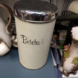 Witte porseleinen pot met metalen deksel en touw, met handgeschreven opschrift 'Beschuit'
