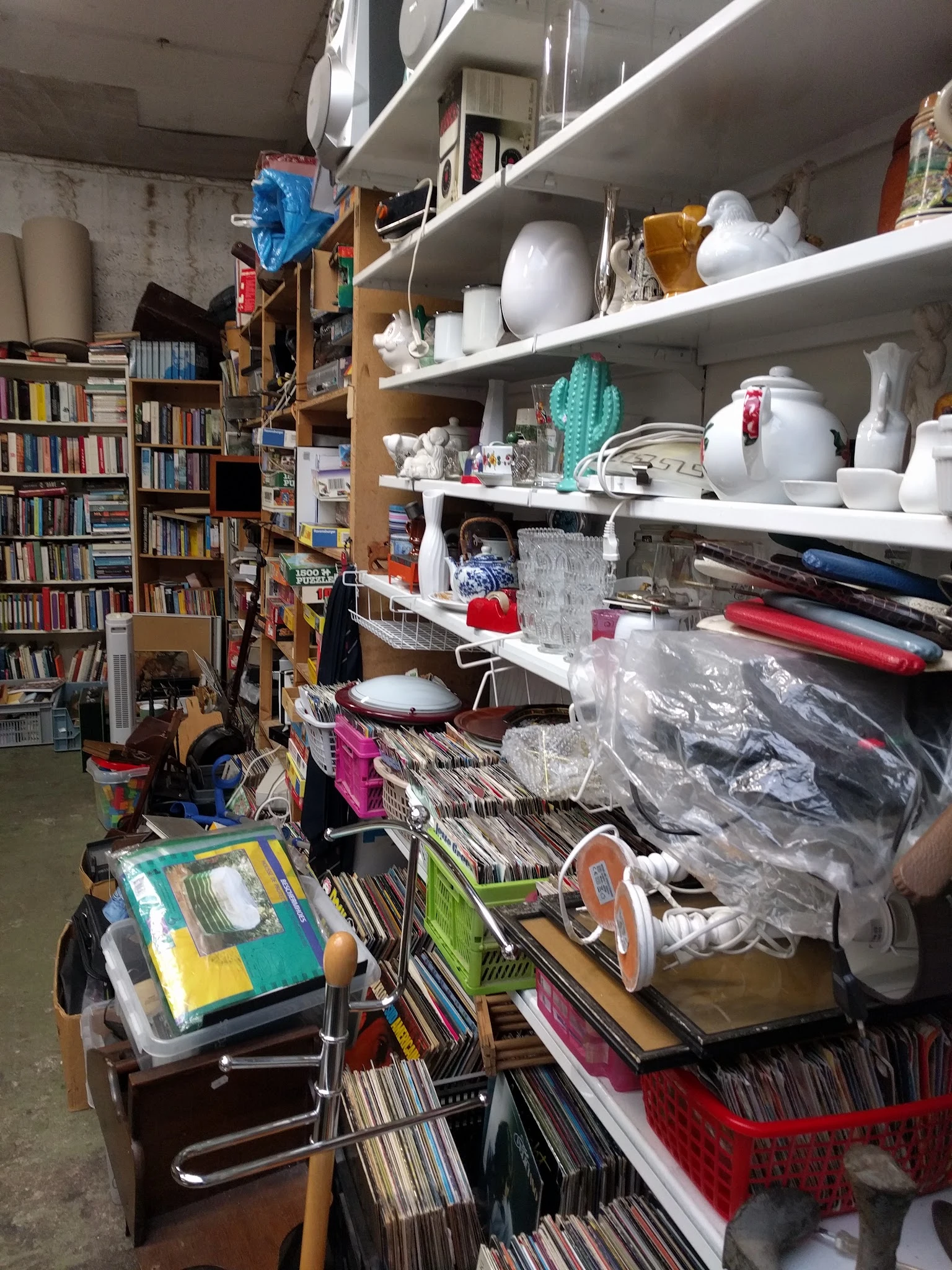 Winkelinterieur met boeken, boekenkasten, stellingen met huishoudartikelen en opslagdozen