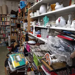 Winkelinterieur met boeken, boekenkasten, stellingen met huishoudartikelen en opslagdozen