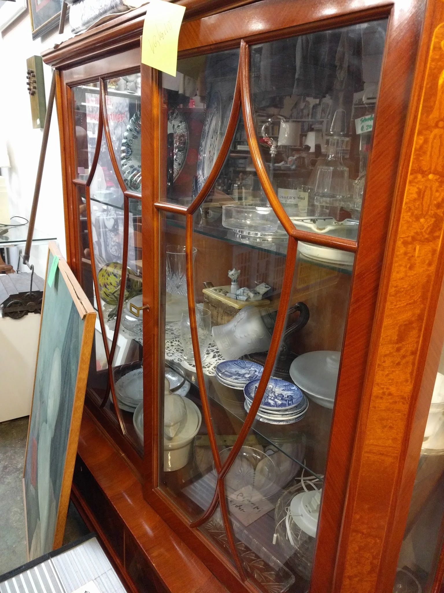 Antieke houten vitrinekast met glazen deuren en blauwe borden op display