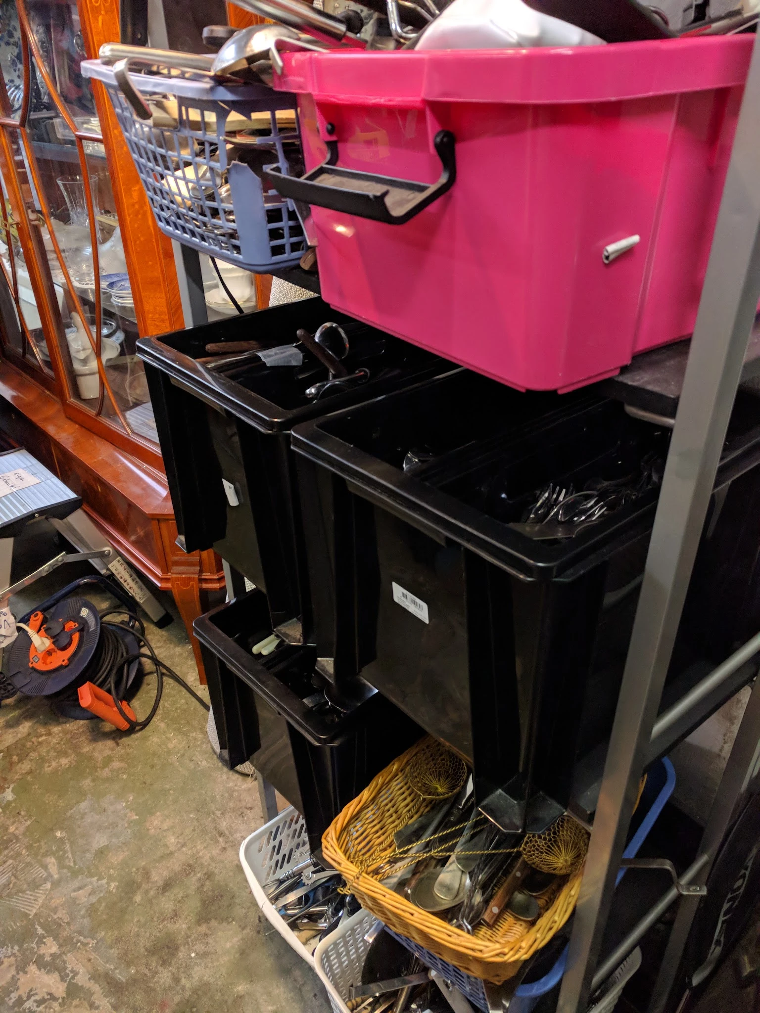 Zwarte en roze plastic opbergboxen en kisten op elkaar gestapeld in de winkel