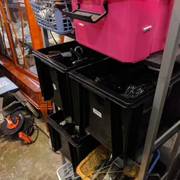 Zwarte en roze plastic opbergboxen en kisten op elkaar gestapeld in de winkel