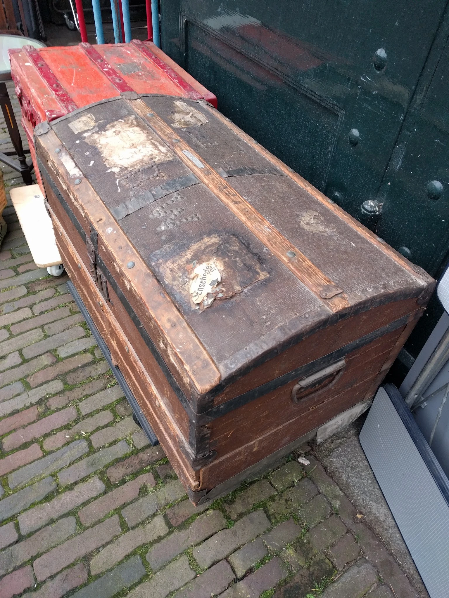 Oude bruine koffer met slijtage op bakstenen ondergrond