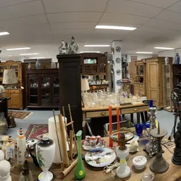 Overzicht van kringloopwinkel met diverse huishoudelijke artikelen, meubels en decoratieve spullen uitgestald