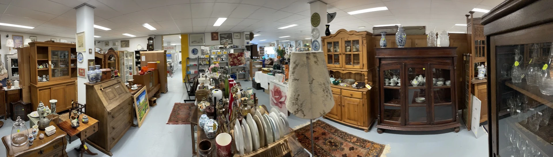 Winkelvloer met diverse tweedehands spullen: servies, meubels, decoratie en huishoudartikelen uitgestald