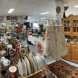 Winkelvloer met diverse tweedehands spullen: servies, meubels, decoratie en huishoudartikelen uitgestald