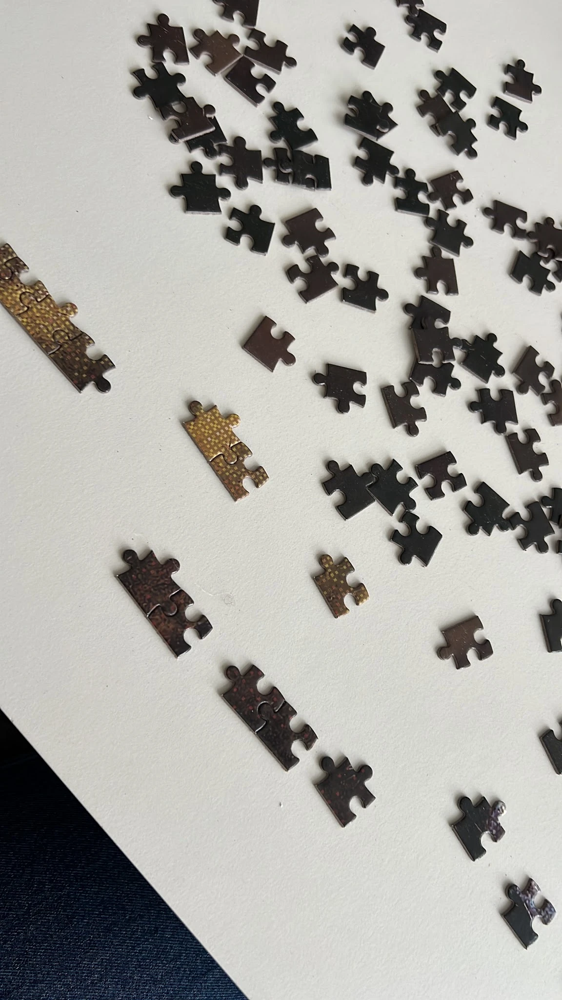 Losse puzzelstukken en puzzelrandstukken in verschillende kleuren op wit oppervlak