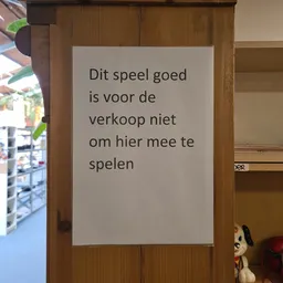 Wit papier met Nederlandse tekst op houten wand