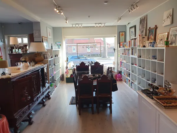 Winkelinterieur met witte stellingen, donkere toonbank en piano in het midden, grote ramen vooraan