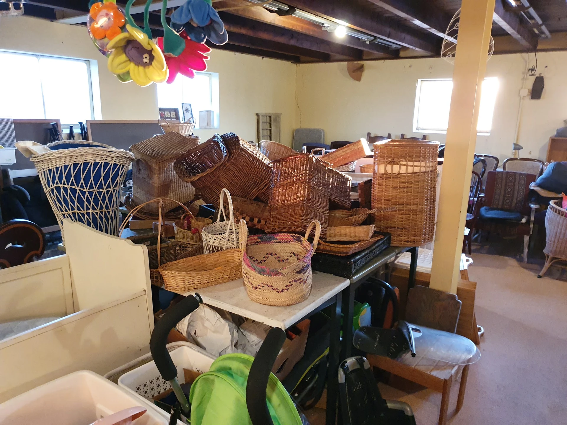 Diverse rieten manden en woven baskets uitgestald op tafels in de winkel
