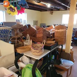Diverse rieten manden en woven baskets uitgestald op tafels in de winkel