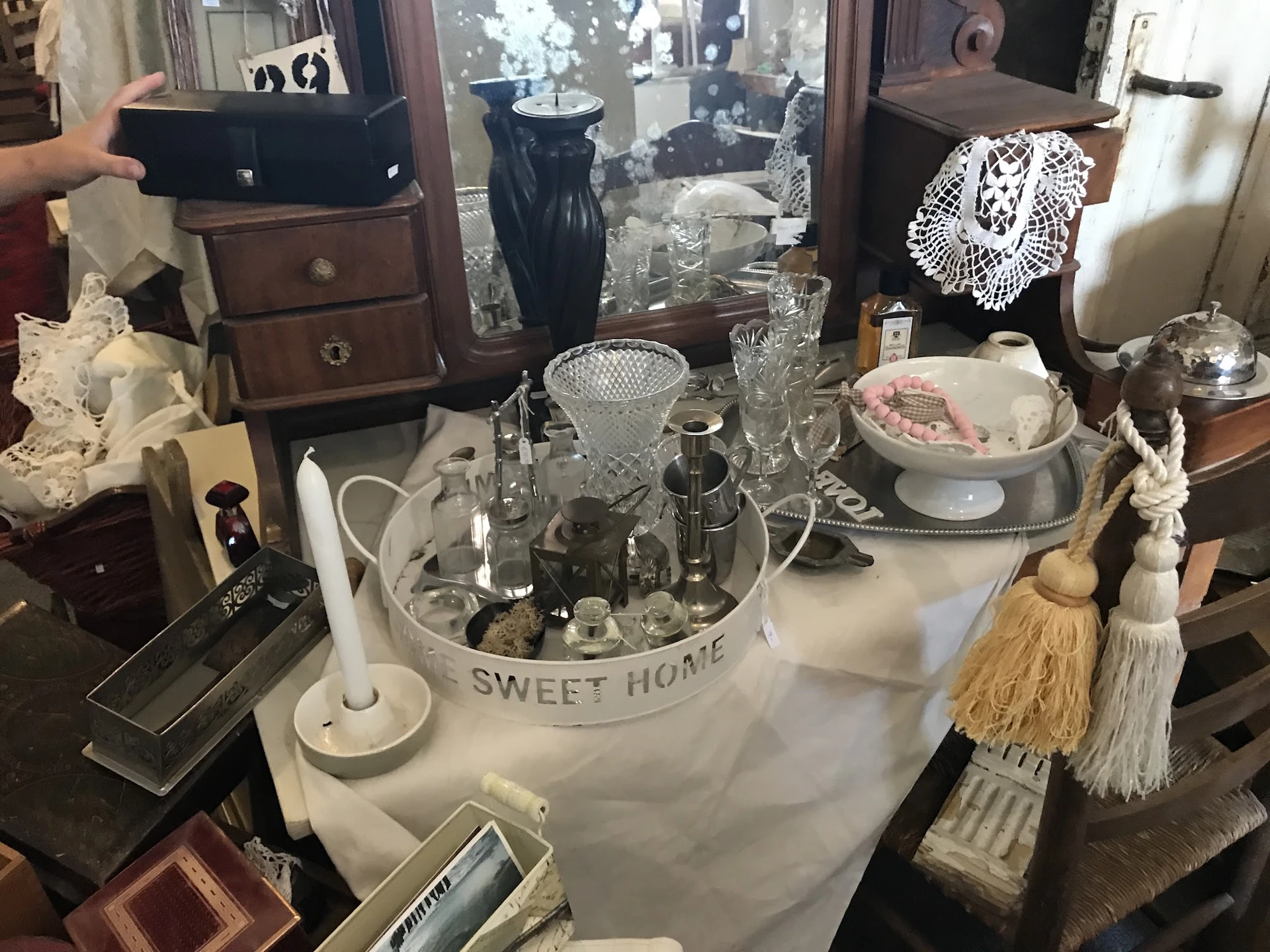 Uitgestalde vintage en antieke huishoudartikelen, glazen, servies en decoratieve items op een tafel
