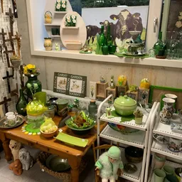 Uitgestalde tuinaccessoires en decoratieartikelen in groene tinten, inclusief potten, dienbladen en plantgerei
