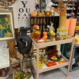 Stellingen met herfst- en winterdecoratie: vogelbeeldjes, kaarsen, pompoen- en bloemenversiering in oranje en geel