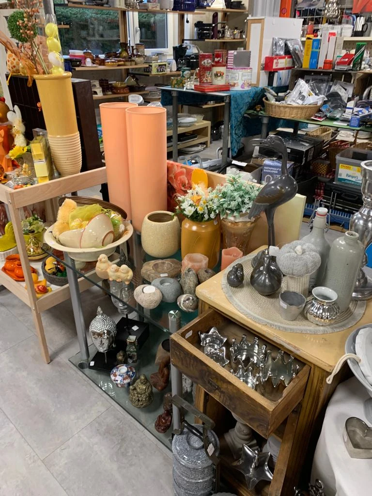 Uitgestalde huishoudartikelen en decoratie: vazen, bloempotten, servies, kandelaars en andere woonaccessoires