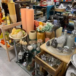 Uitgestalde huishoudartikelen en decoratie: vazen, bloempotten, servies, kandelaars en andere woonaccessoires