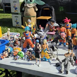 Verzameling speelgoedactiefiguren en collectibles uitgestald op een tafel buiten