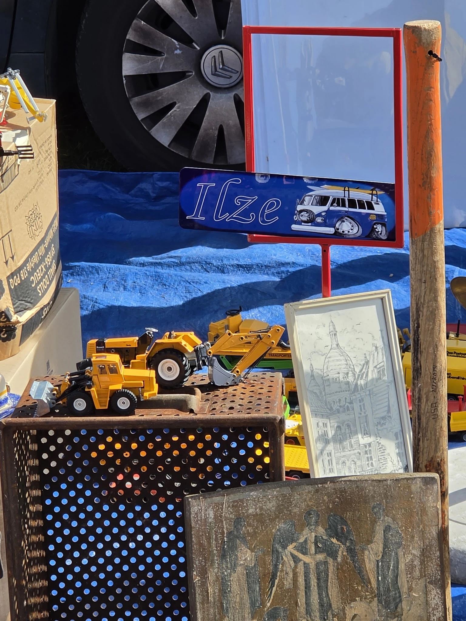 Uitgestalde speelgoedvoertuigen en constructiemodellen op een kraam met blauwe achtergrond