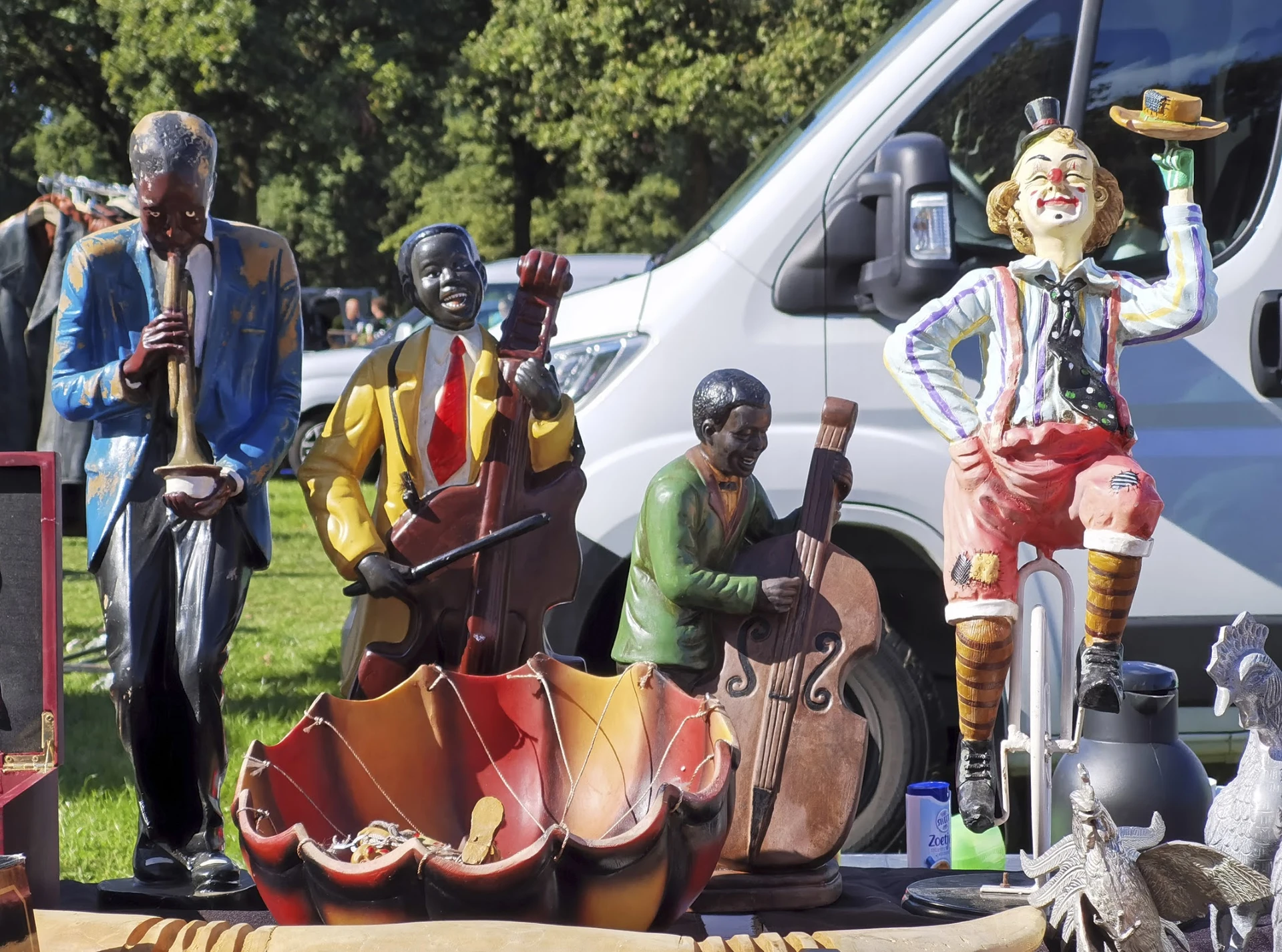 Decoratieve beelden van muzikanten in verschillende kleuren uitgestald op een terras