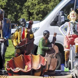 Decoratieve beelden van muzikanten in verschillende kleuren uitgestald op een terras