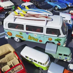 Twee miniatuurbusjes uit een speelgoedcollectie, waarvan één wit-groen met 'LOVE'-opschrift en gele surfboards op het dak