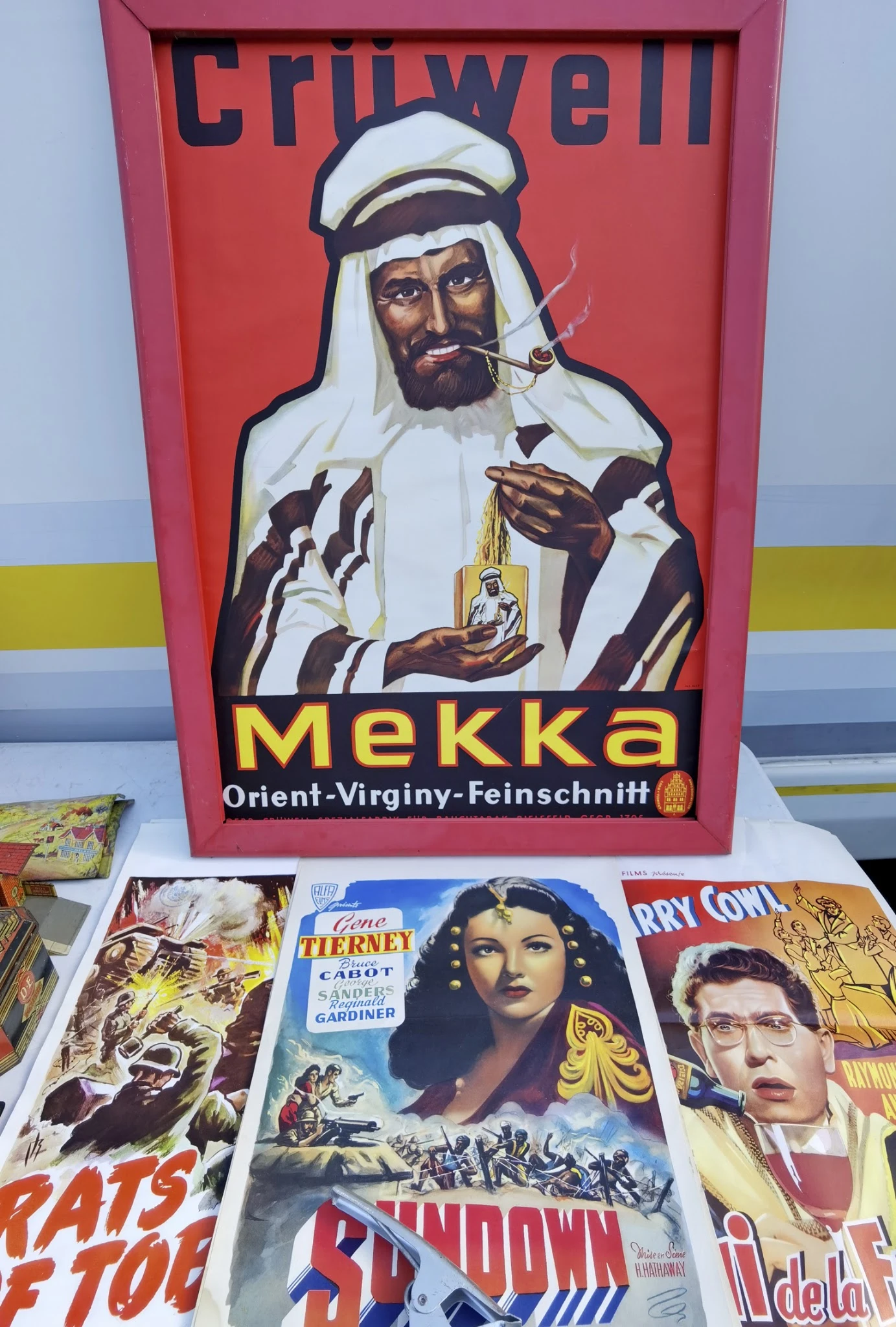 Vintage reclamebord Mekka-likeur naast oude filmposters en boeken in de winkel