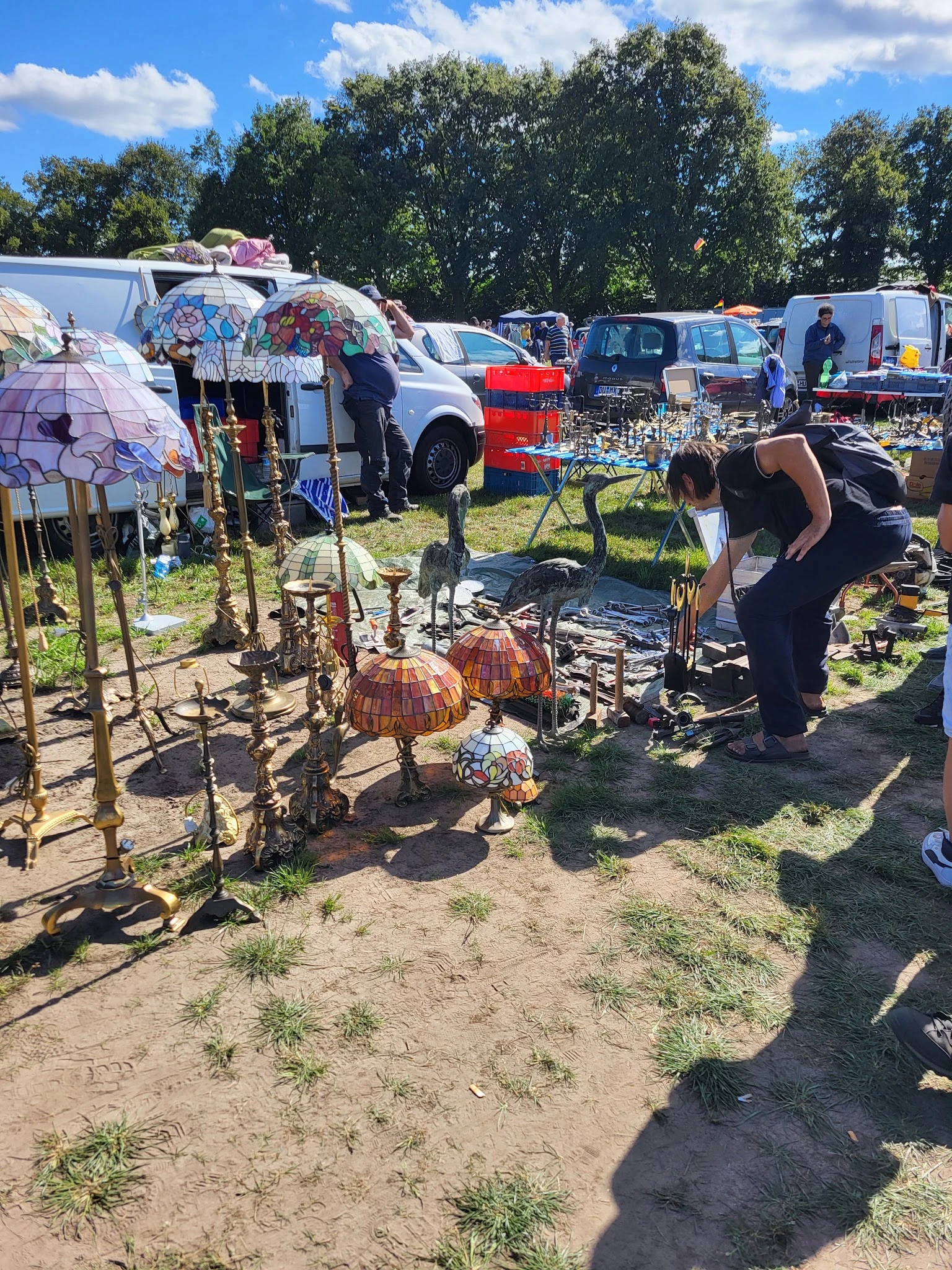 Verschillende tweedehands items uitgestald op een carbootsale, waaronder decoratieve artikelen, gereedschap en huishoudelijke