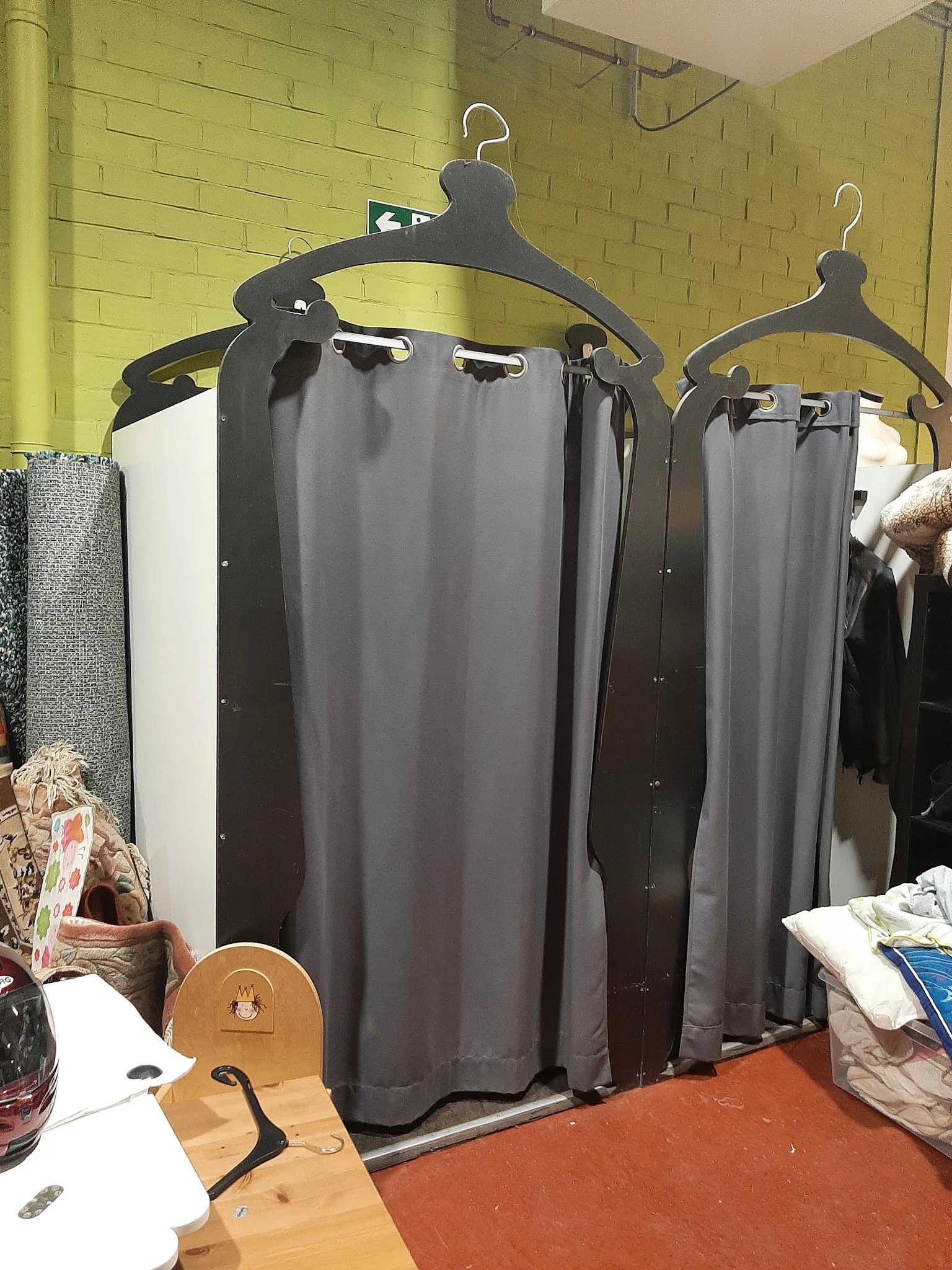 Uitgestalde gordijnen en andere textielwaren in een kringloopwinkel