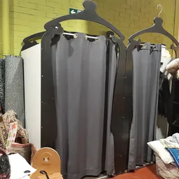Uitgestalde gordijnen en andere textielwaren in een kringloopwinkel