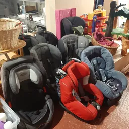 Verzameling tweedehands autostoeltjes voor baby's en kinderen op de winkelfloor