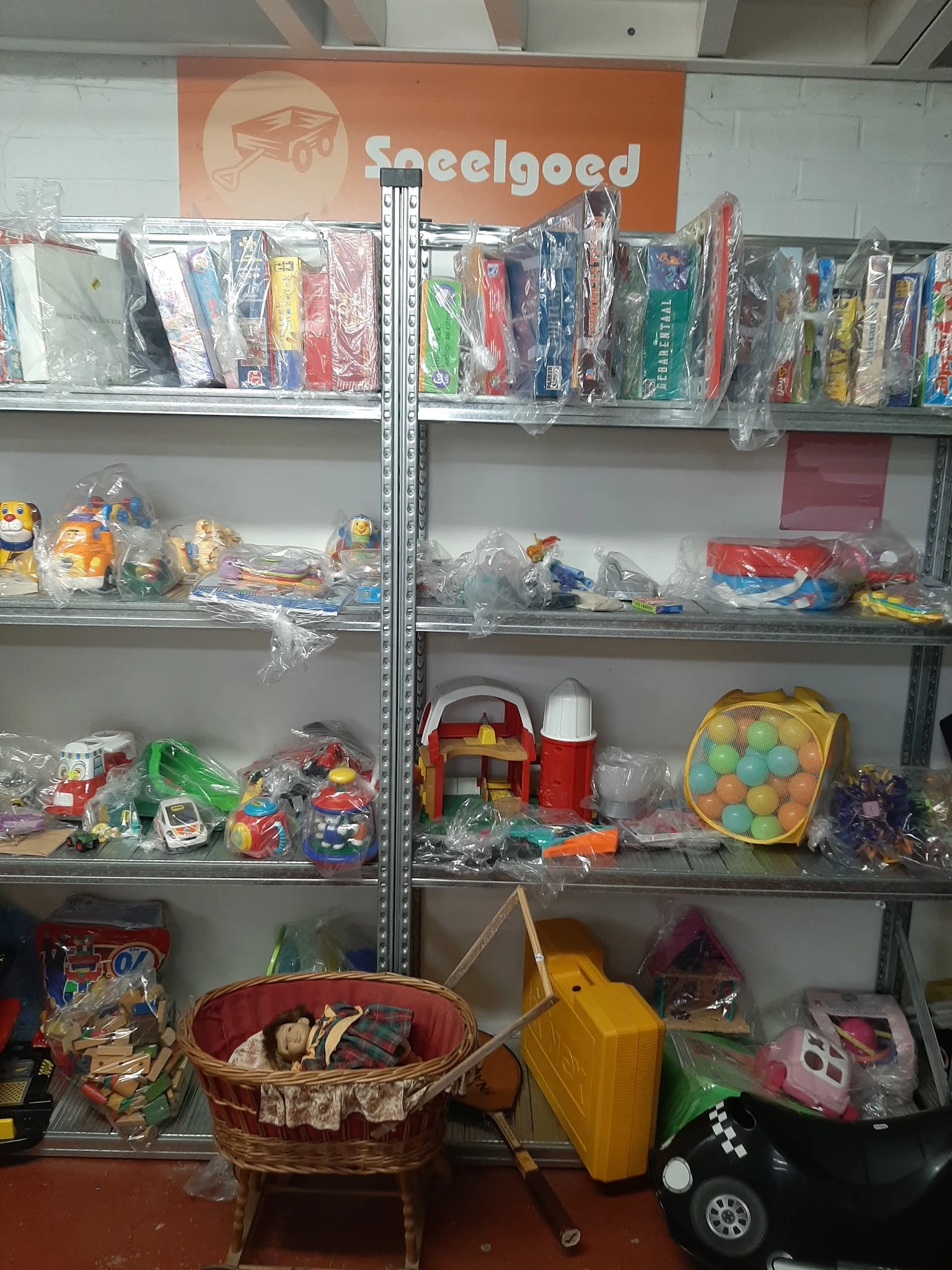 Metalen stellingen met speelgoed en kinderspullen in plastic verpakking