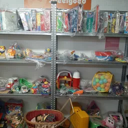 Metalen stellingen met speelgoed en kinderspullen in plastic verpakking