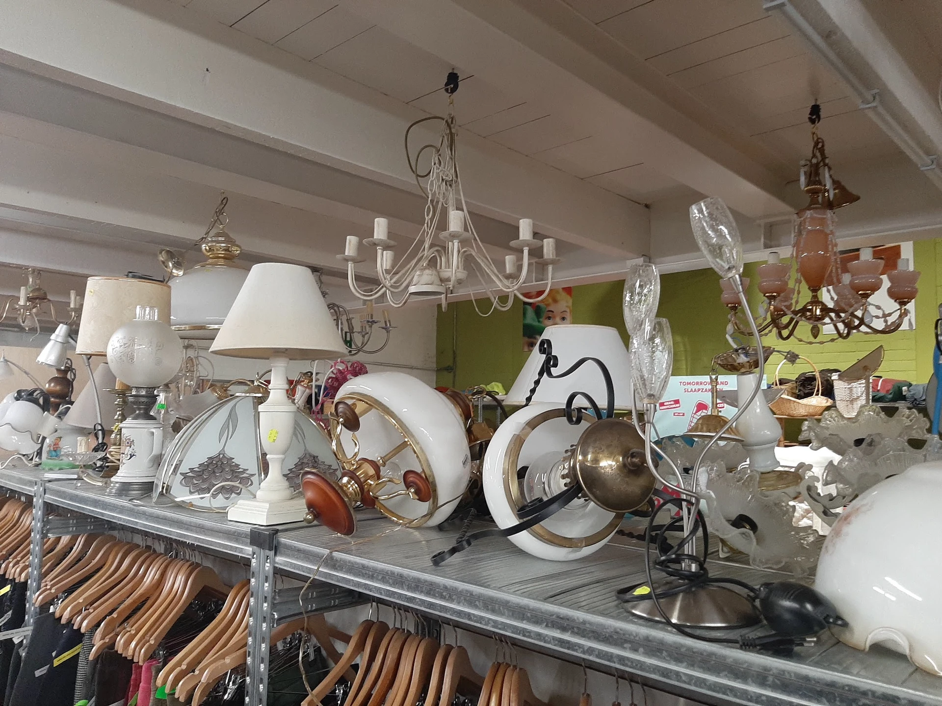 Uitgestalde lampen, kroonluchters, servies en decoratieve items op een tafel in de winkel