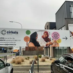 Gevel van kringloopwinkel Cirkels met groot uithangbord, openingstijden en contactgegevens zichtbaar