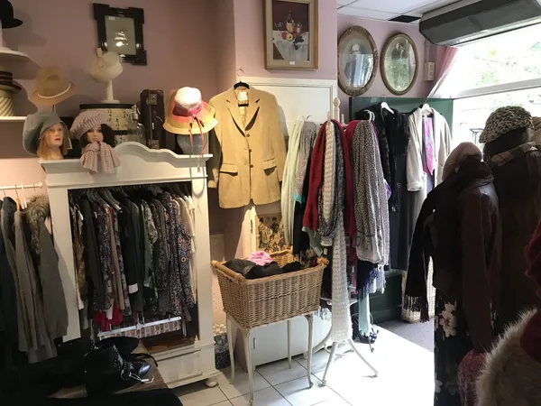 Winkelinterieur met kledingrekken, mannequins met kleding, tassen en accessoires