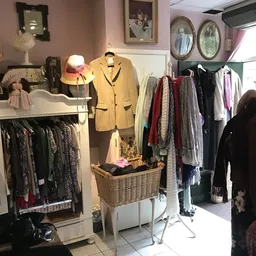 Winkelinterieur met kledingrekken, mannequins met kleding, tassen en accessoires