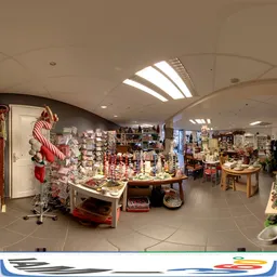 Winkelvloer met stellingen en uitgestalde kerstdecoratie, huishoudartikelen en diverse spullen onder gebogen plafond met dakl