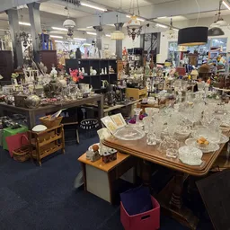 Overzicht van de winkelruimte met tafels vol kristalwerk, glaswerk en decoratieve items