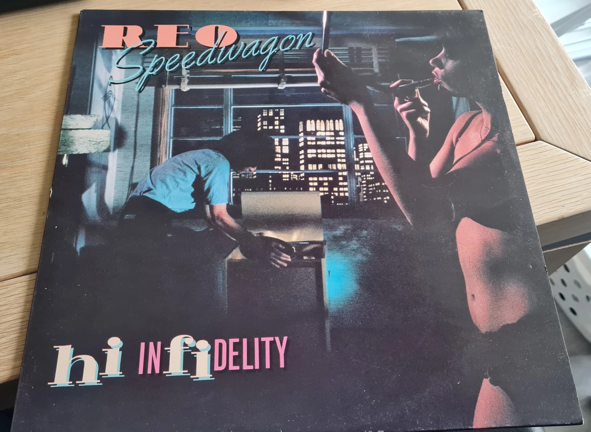 Vinyl LP-plaat 'REO Speedwagon - Hi Infidelity' met albumhoes op houten ondergrond