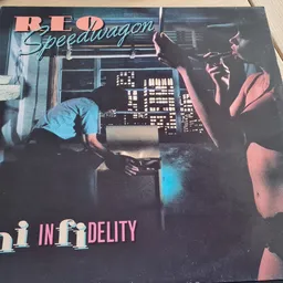Vinyl LP-plaat 'REO Speedwagon - Hi Infidelity' met albumhoes op houten ondergrond
