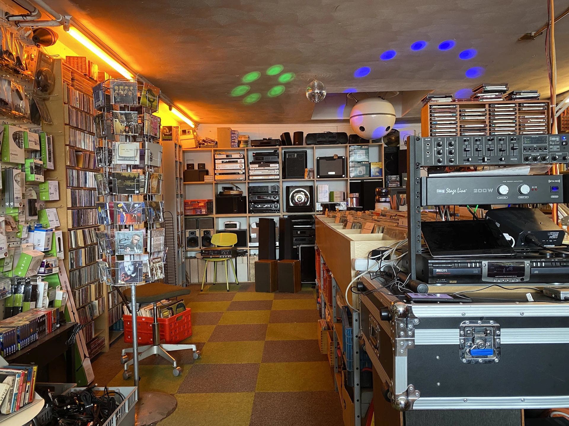 Winkelbinnenruimte met cd- en dvd-rekken, boekenkast, audiovisuele apparatuur en gekleurde verlichting aan het plafond