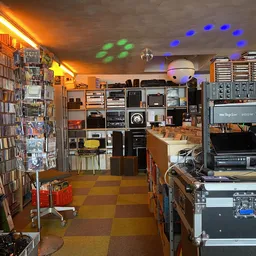 Winkelbinnenruimte met cd- en dvd-rekken, boekenkast, audiovisuele apparatuur en gekleurde verlichting aan het plafond