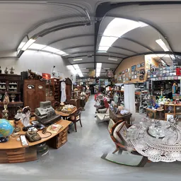 Ruim interieur van kringloopwinkel met diverse meubels, huishoudartikelen en spullen uitgestald onder verlichte plafondpanele