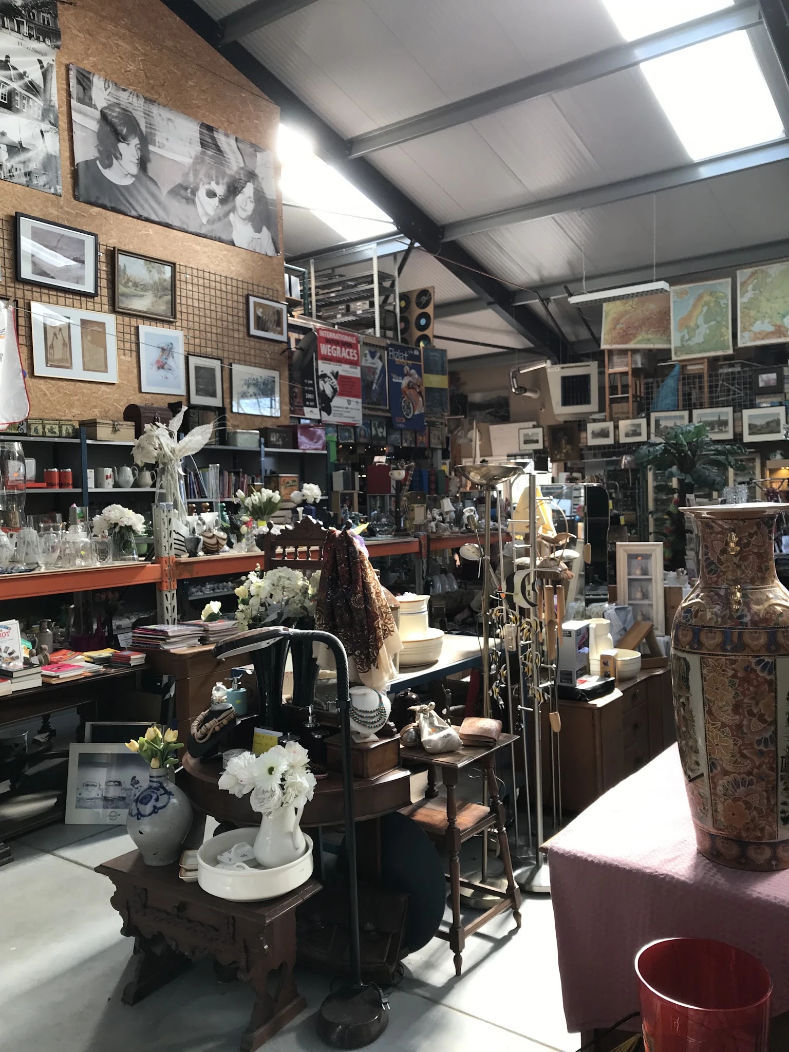 Winkelvloer van kringloopwinkel met meubels, kunstwerken, vazen en decoratieartikelen aan alle kanten
