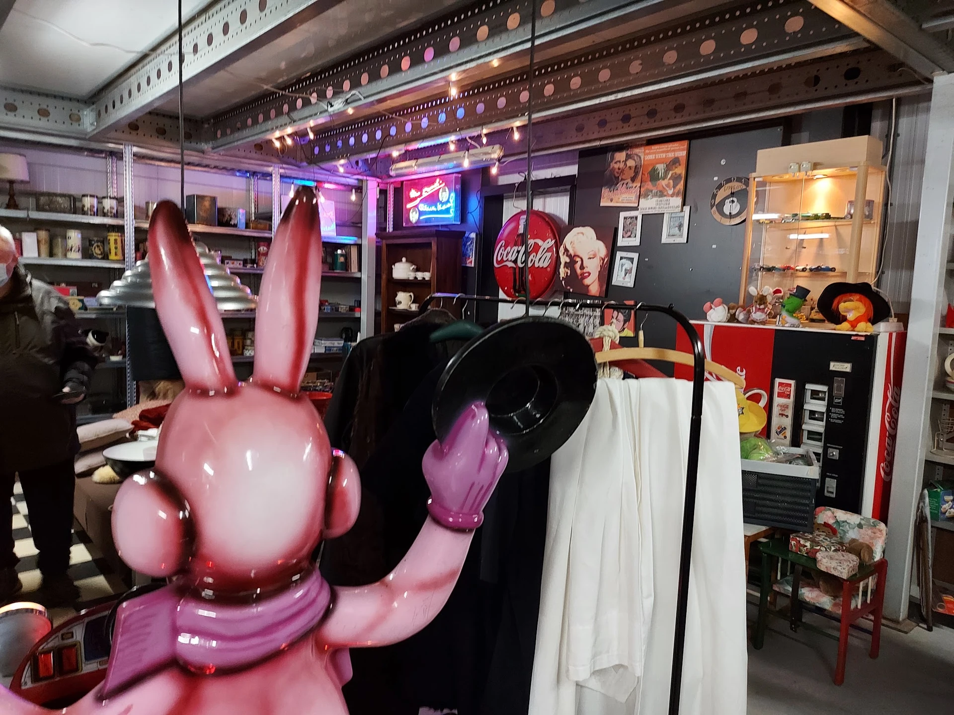 Winkelbinnenruimte met stellingen, decoraties en een grote roze konijnfiguur op de voorgrond