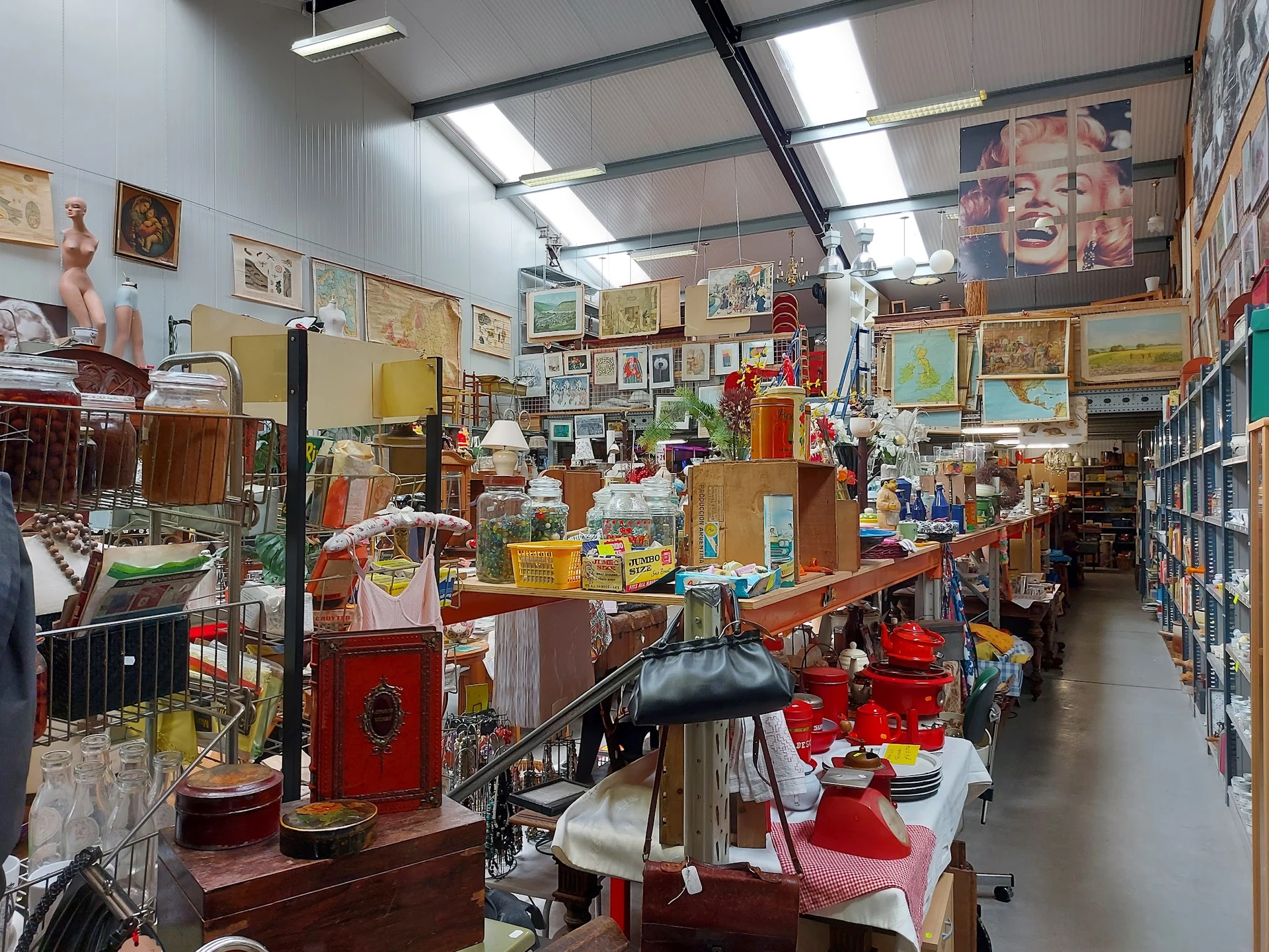 Overzicht winkelvloer kringloopwinkel met diverse spullen, meubels, kunstwerken en huishoudartikelen