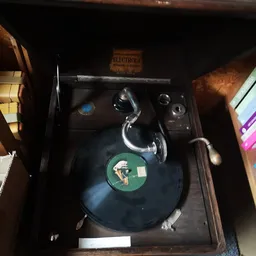 Vintage Electrola grammofoon met zwarte draaitafel en chromen toonarm in open kast
