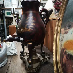 Antieke bronzen driepotige vaas met patina en decoratieve hengsels